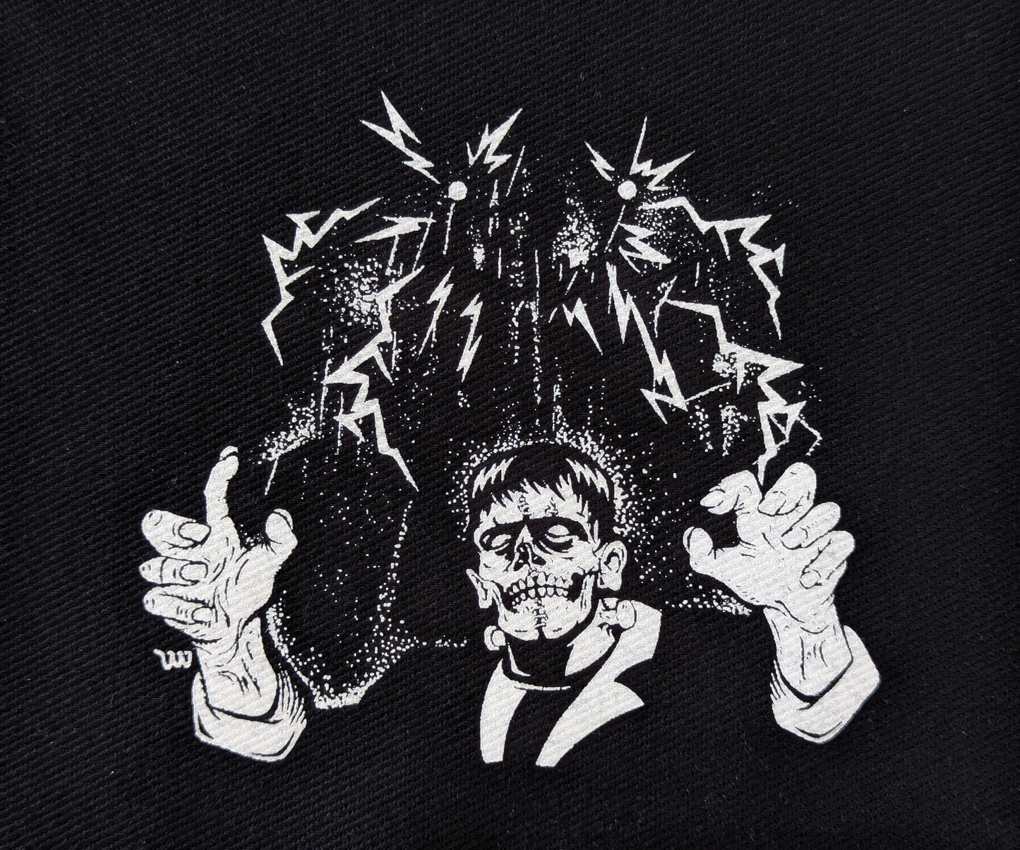 Black and white illustration of a skeleton Frankenstein on a textured black background