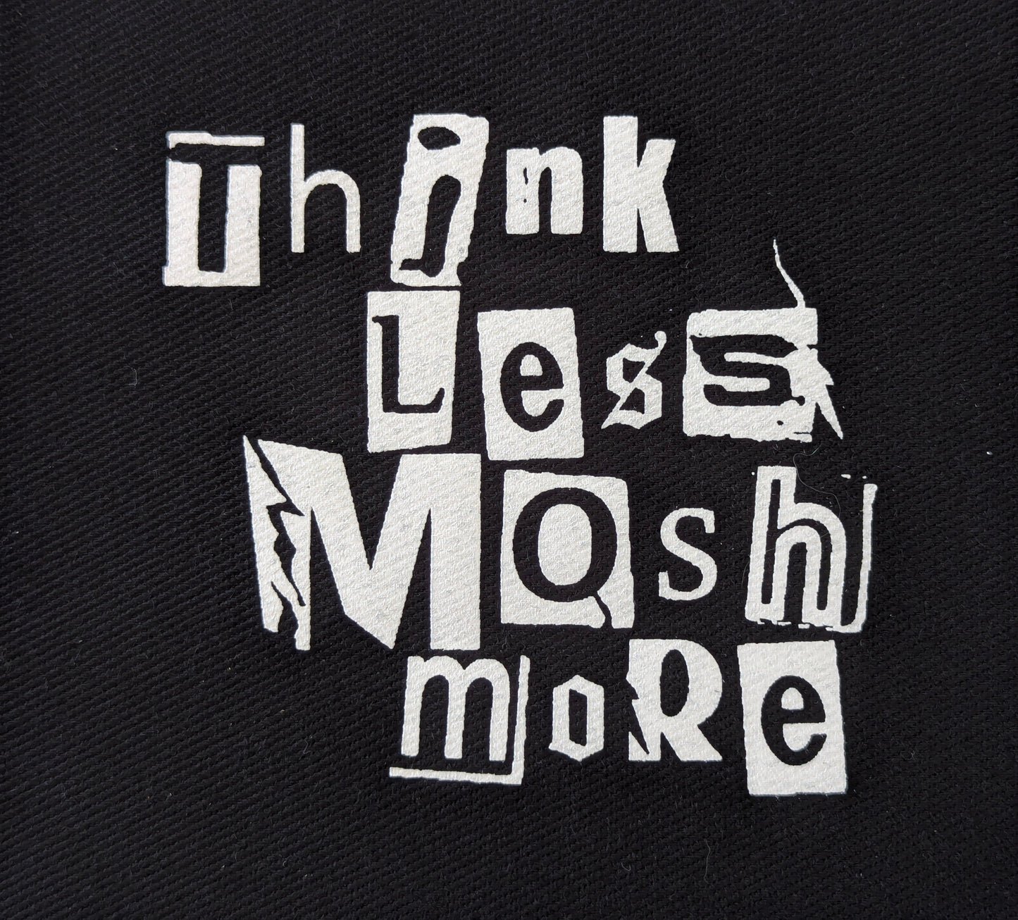 Black patch with white text, punk-style font 'Think Less Mash More' on a textured black background
