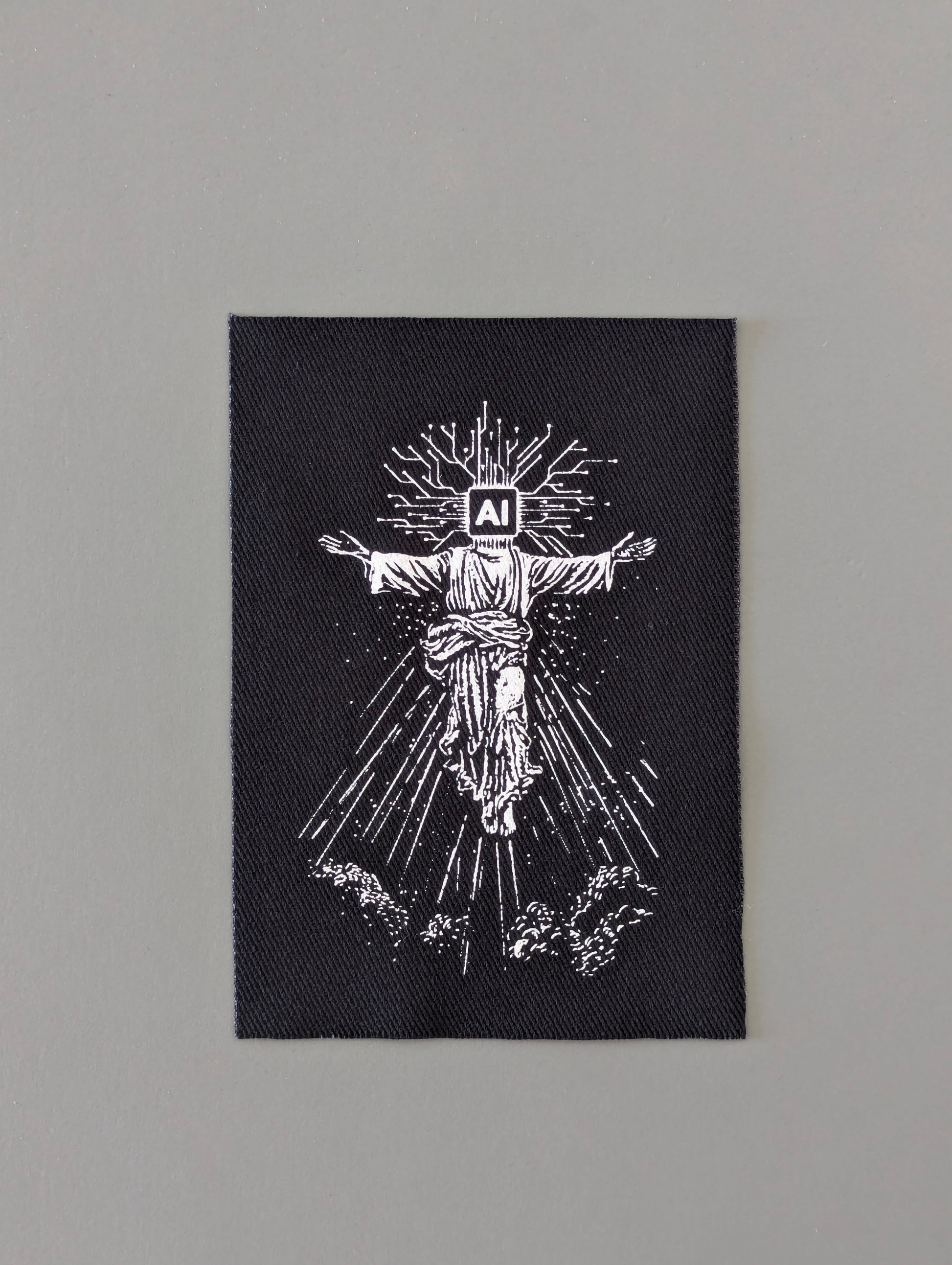 Black patch with white illustration of a prophet with 'AI' on its head, symbolizing humanity will depend on Artificial Intelligence 